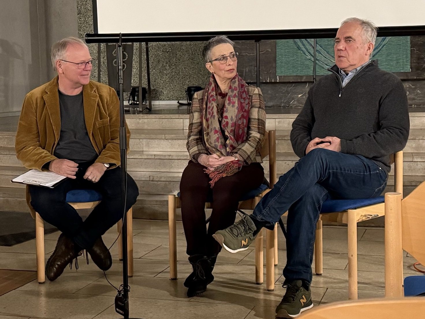 Veranstaltung in der neuen Nicolaigemeinde, Frankfurt Im Gespräch zu sehen sind v. l. n. r.: Gottfried Kößler, Judy Rosenthal, Frank Paulun Herr Paulun spricht, während Frau Rosenthal und Herr Kößler im zugewandt zuhören.
